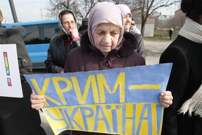 Elderly Crimean woman in 2014 with a placard reading Crimea is Ukraine