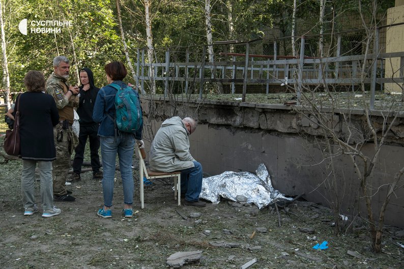 1 червня 2023 року. Дідусь дев’ятирічної дзюдоїстки Вікторії Івашко, який сидить біля тіла загиблої онуки. Як писали журналісти, дідусь не відходив від Вікторії, аж поки її тіло не забрали судмедексперти. Бабусі дівчинки стало зле під час упізнання тіла, її забрала “швидка”. Фото: Владислав Мусієнко / “Суспільне”.